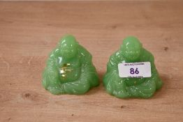 Two contemporary glass seated Bhudda figurines, of a light green colour, unmarked but pontil marks