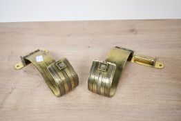 Two presumed 20th-century small brass curtain holdbacks, having foliate decoration, unmarked,