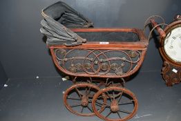 A sweet 19th-century wicker and metal dolls-pram, having decorative scrollwork, a black fabric