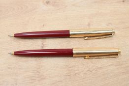 Two Parker 45 ballpoint pens in red with rolled gold cap. Slight dent to one cap
