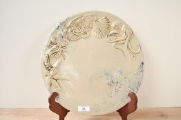 A large contemporary studio pottery charger, featuring marine-themed embossed designs of shrimps,