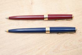 Two Parker 17 Super Duofold ballpoint pens in blue, red with gold trim