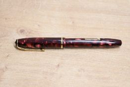 A Conway Stewart 15 lever fill fountain pen in Red Pink and Black marble with single cap band having