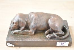 A contemporary cast and patinated bronze Labrador Retriever statue, in a recumbent position upon a