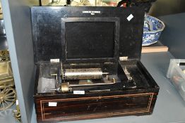 A late 19th to early 20th-century cylinder music box, rosewood with inlaid decorative elements and