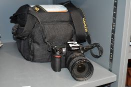 A Nikon D80 digital camera with AF S Nikkor 18-200mm 1:3,5-5,6 G ED lens having charger and