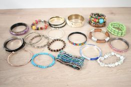 A collection costume bangles, including beaded pieces and wooden examples