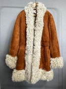 A circa 1960-70s Afghan coat in 100% lambskin shearling, having a orange-tan suede outer with