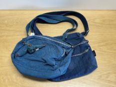 A Kipling cross body bag in teal, with monkey keychain in tact, along with a blue Jouney cross