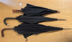 Three antique and vintage mourning umberellas, a British Made with leather covered handle and