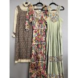 Three retro 20th century vintage British-made dresses in warm earth tones, comprising a full