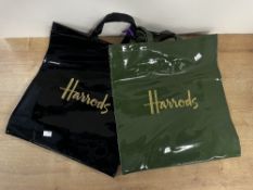 Two vintage Harrods PVC shopper tote bags, a black and a hunters green, each bearing the gold