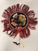 An antique handheld face fan featuring plush velvet embroidery depicting three flowers with beading,