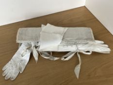 A broderie and quilted satin wrap containing assorted antique and later ladies evening gloves,