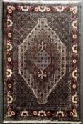 A Persian Senneh or Bidjar hand knotted rug, having a central floral diamond design with miltiple