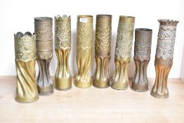 A group of eight French and British World War I brass trench art shell cases, each embossed and