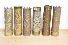 A group of six World War I French brass trench art shell cases each embossed and hand hammered