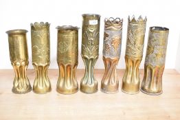 A group of seven French, British and Italian brass World War II trench art shell cases, each with