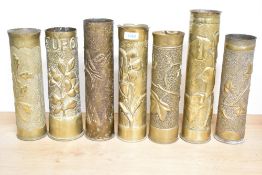 A group of seven French and British World War I brass trench art shell cases, each embossed and