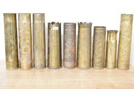 A group of nine British and French World War I brass trench art shell cases, each with hand-engraved