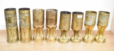 Four pairs of German World War I brass trench art shell cases, each embossed or engraved over