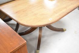 An early 20th Century Regency revival mahogany extending twin pedestal dining table of typical