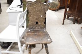 A stained frame hall chair , in need of repair, having foliate shield back and turned legs