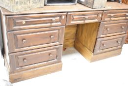 A modern reproduction stained wood desk or dressing table, having an arrangement of seven drawers