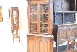 A reproduction mahogany double corner cupboard, with dentil moulded frieze and astragal glazed