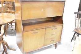A vintage sapele side cabinet having drop flap section over cupboard and drawer base, dimensions