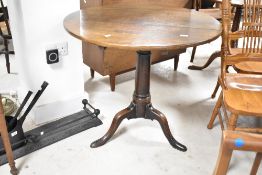 A 19th Century oak pedestal table having circular top, turned column and triple splay legs, having