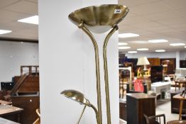 A modern brass effect standard lamp having uplighter and gooseneck reading light