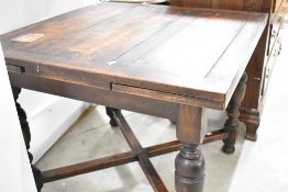 An early to mid 20th Century oak drawer leaf table on turned legs with cross stretcher, closed