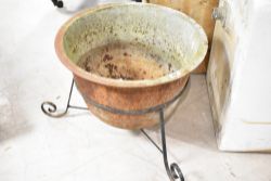 An antique set pot/wash boiler on wrought stand, drainage holes to bottom, suitable as garden
