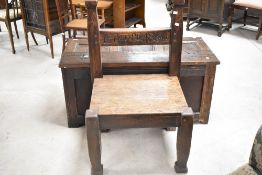 A 19th Century oak chair of large rustic proportions, with solid seat, possibly a 'discipline'
