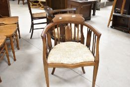 A pair of Edwardian mahogany bedroom armchairs having later upholstery, on square tapered legs and