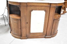 A Victorian walnut credenza having marble top, with mirror door to central cupboard, flanked by open