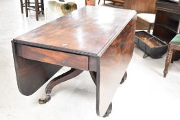 A 19th Century mahogany drop leaf dining table, having turned column and quadruple carved shaped