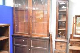A 'married' bookcase over double cupboard, the 19th Century mahogany glazed section over similar