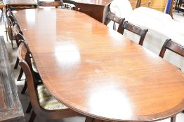 A reproduction Regency triple banquetting style dining table and eight (six plus two) similar dining
