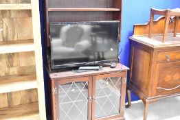 A late 20th Century mahogany effect lounge unit comprising shelves over faux leaded glass lower