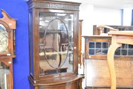 An Edwardian mahogany display cabinet having glazed upper section with bow fronted cupboard base,