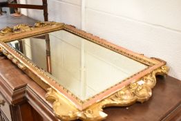 A 19th Century gilt frame mirror having wheatsheaf finial and rococco style surround, in some