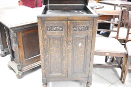 A HMV oak gramophone cabinet, of traditional form with hinged square section cover over carved and