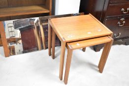A vintage teak part nest of table (G plan or similar) and a similar wall mirror