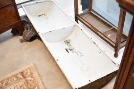 A very heavy vintage cast iron and enamelled double animal feed trough, with drainage to base,