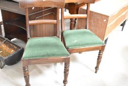 A pair of Victorian mahogany rail-back dining chairs with plain curved top and mid-rails over the
