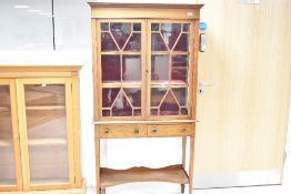 An Edwardian mahogany display cabinet having astral glazed display cabinet over two drawers and
