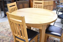 A modern golden oak extending dining table of circular form, diameter approx. 120cm, plus