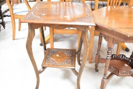 A Victorian oak occasional table having square carved top , shaped leg and carved undertier, width